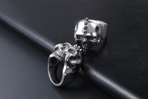 Macro shot of gothic silver skull rings with blackened vintage detail on black leather