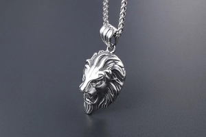 Vue détaillée d'un pendentif tête de lion argenté avec des textures de crinière sur une chaîne