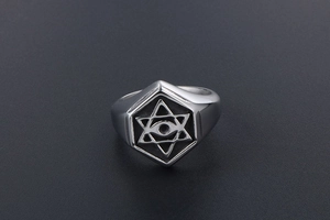Macro shot of silver stainless steel signet ring with engraved hexagram and all-seeing eye