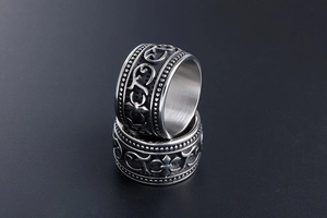 Close-up of retro titanium steel rings featuring gothic cross and floral scroll engravings
