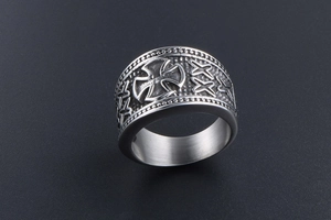 Macro detail of gothic cross emblem and textured finish on wide titanium steel ring