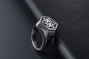 Macro shot of silver titanium steel ring with starburst and all-seeing eye engraving