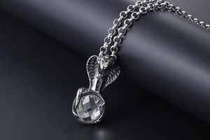 Detailed view of gothic cobra pendant with clear faceted crystal on a metal chain