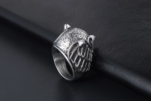 Macro side view of vintage stainless steel owl ring with detailed feather engravings