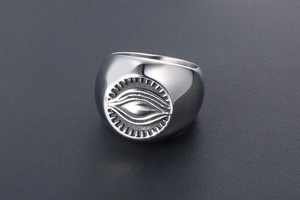 Close-up of vintage steel signet ring with engraved Eye of Providence and sun rays