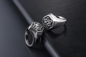 Macro detail showing vintage hexagon rings with engraved star and eye on black leather