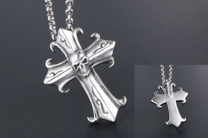 Macro detail of gothic cross skull pendant showing smooth metal back and intricate carvings