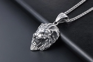 Gros plan du pendentif tête de lion en argent avec crinière et chaîne torsadée