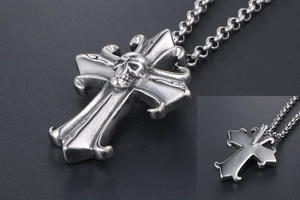 Macro shot of gothic cross necklace with skull detail and vintage stainless steel finish