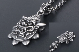 Close-up of vintage silver dragon pendant showing detailed textures and gothic style