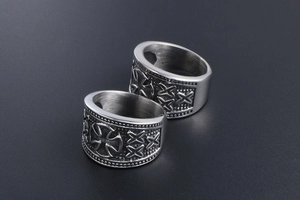 Detailed macro of vintage titanium steel cross rings with textured brushed metal finish
