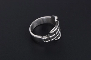 Detailed macro view of punk style stainless steel skull hand ring with matte silver finish