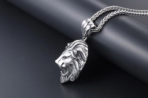 Gros plan détaillé d'un pendentif tête de lion rugissant avec textures de crinière et chaîne