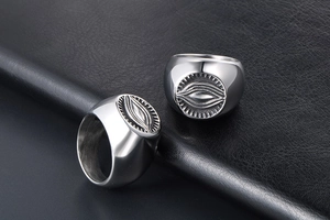Macro view of two vintage silver titanium steel signet rings with mystic eye engraving