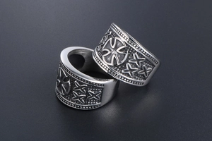 Close-up of vintage titanium steel cross rings with black oxidized rock finish