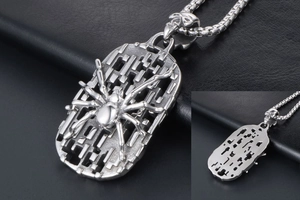 Detail of spider pendant with hollow geometric base and skull clasp on steel chain