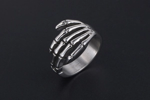 Detailed close-up of punk style stainless steel skeleton hand ring with vintage finish