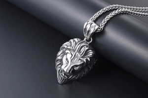 Gros plan détaillé du pendentif tête de lion texturé avec chaîne en maille épi