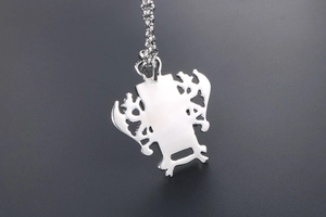 Vue macro du pendentif bouclier dragon sculpté avec texture en acier inoxydable brossé