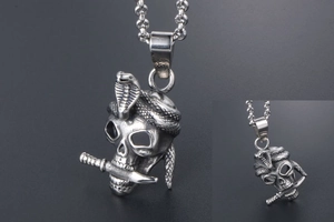 Macro detail of punk skull pendant with cobra and dagger in aged stainless steel
