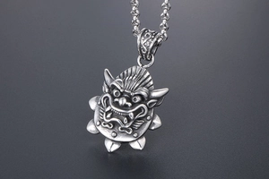 Macro shot of titanium steel dragon pendant featuring detailed vintage relief carving