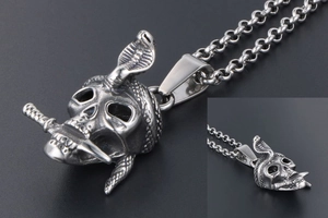 Macro shot of gothic skull pendant with cobra and dagger in aged silver steel
