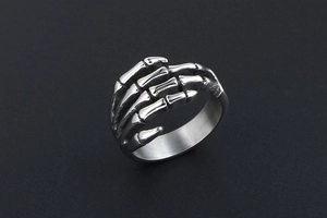 Detailed view of punk style stainless steel skull hand ring with vintage silver finish