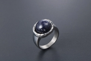 Vue détaillée d'une bague large en acier argenté avec grès bleu rond étincelant