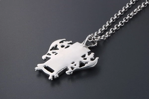 Détail macro du pendentif dragon poli en acier inoxydable avec des motifs ajourés