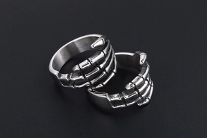 Detailed view of dual punk gothic skull hand rings in brushed stainless steel