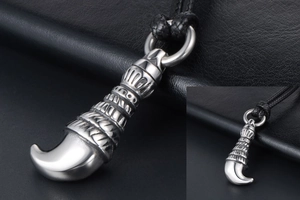 Macro view of men's titanium wolf tooth pendant with retro carved textures and black cord