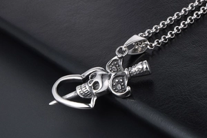 Vue détaillée du pendentif crâne et dague punk en acier inoxydable avec finition argentée vintage