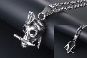 Macro detail of gothic skull pendant with cobra and dagger in durable titanium steel