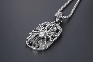 Macro shot of vintage steel spider shield pendant with skull clasp on pearl chain