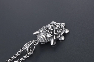 Macro side view of a gothic dragon face pendant with detailed vintage punk engraving