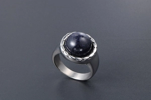 Vue détaillée d'une bague en grès bleu avec acier brossé et effet de lumière étoilée