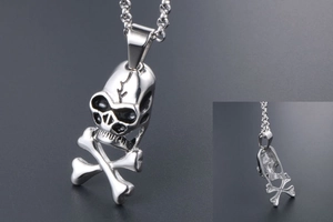 Macro detail of a retro punk skull and crossbones pendant in polished titanium steel