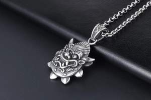 Detailed view of carved dragon head pendant in vintage titanium steel with punk style chain