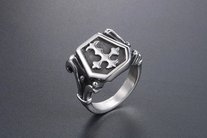 Close-up of retro signet ring with shield-shaped cross relief and brushed steel texture