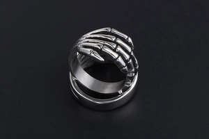 Detailed view of punk skeleton hand ring in vintage cast titanium steel on dark background