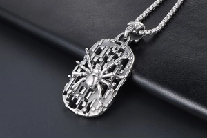Detail of vintage silver spider shield pendant with skull bail and box chain necklace