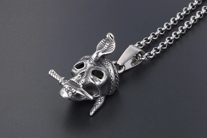 Detail of gothic skull pendant with cobra and sword in vintage silver finish