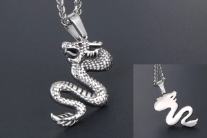 Macro detail of silver dragon pendant necklace with scale patterns and polished metal back