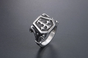 Close-up of retro gothic shield ring with cross pattern and scrollwork engraving