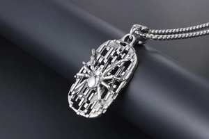 Macro shot of 3D spider pendant with hollow mesh base on stainless steel box chain