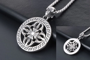 Detail of vintage stainless steel pendant with vajra cross design and skull buckle on box chain