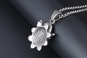 Macro shot of the detailed textured back of a vintage silver sunflower pendant