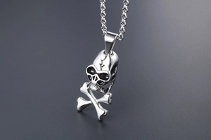Macro shot of silver skull and crossbones pendant with black oxidation detail