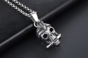 Detailed close-up of gothic stainless steel skull pendant with snake and sword on Rolo chain