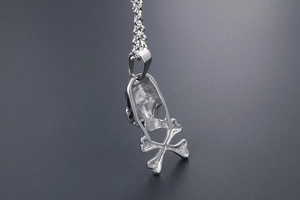 Macro view showing the hollow back structure and thick metal clasp of the skull pendant